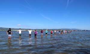 Pla general dels participants fent la cadena humana a la badia del Fangar, a l'Ampolla (Baix Ebre), per denunciar la regressió que pateix el delta de l'Ebre.