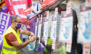 Persona pegando carteles en la manifestación contra el ERE del banco Sabadell