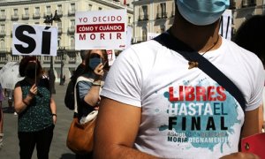 Un grupo de personas se reúne sosteniendo pancartas y carteles durante la concentración de la asociación Derecho a Morir Dignamente (DMD) en la Puerta del Sol, a 25 de junio de 2021, en Madrid, (España).