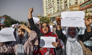 Mujeres afganas corean consignas y sostienen carteles durante una protesta por los derechos de las mujeres en Kabul el 21 de octubre de 2021.