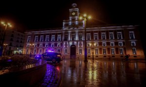 Un coche de la Policía Nacional circula en la Puerta del Sol durante la primera noche de toque de queda en Madrid