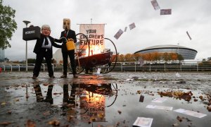 Activistas hacen una performance contra los combustibles fósiles en los aledaños del pabellón donde se celebrará la COP26.