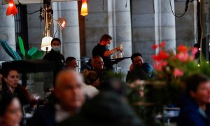 Un camarero atiende una mesa en una de las terrazas de la madrileña Plaza Mayor. REUTERS/Susana Vera