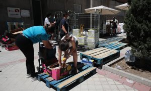 29/05/2020 Una mujer recoge productos que le entrega una voluntaria.