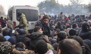 Refugiados y migrantes se agolpan para recibir ayuda humanitaria distribuída por soldados bielorrusos en un campo en la frontera con Polonia en la región de Grodno.