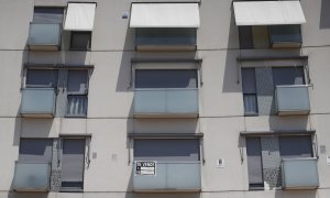 Cartel de se vende en el balcón de un piso de un edificio de Madrid.