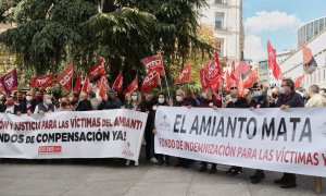 Varias personas con varias pancartas, durante una concentración para el desbloqueo de la ley para la creación de un fondo de compensación de las víctimas del amianto, en el Congreso de los Diputados, a 4 de noviembre de 2021.