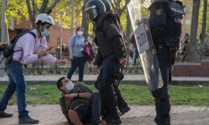 El periodista Guillermo Martínez, en el suelo junto a dos policías antidisturbios, el 7 de abril de 2021, día del mitin de Vox en Vallecas