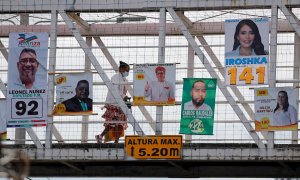 23/11/2021 Una mujer camina por un puente peatonal donde han instalado propaganda política en Tegucigalpa (Honduras)