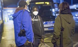 Una persona migrante es recibida por voluntarios de la red de acogida tras llegar a la estación de autobuses de Irún, en Gipuzkoa.