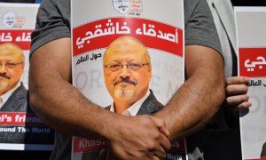 Amigos del periodista saudita asesinado Jamal Khashoggi sostienen carteles con su foto.