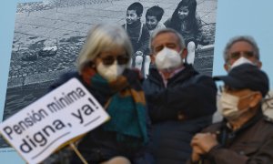 Un grupo de personas con un cartel durante una manifestación que reclama el blindaje de las pensiones en la Constitución, a 13 de noviembre de 2021, en Madrid.