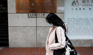 Una mujer pasa por delante de la entrada del China Evergrande Centre, en Hong Kong. REUTERS/Tyrone Siu