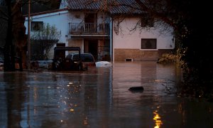 El río Arga se desborda a la altura del puente de Curtidores en el barrio de la Rochapea en Pamplona, este viernes.