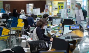 ARCHIVO. Varios empleados trabajan en la Oficina de Correos de Cibeles, en Madrid.