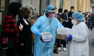 Dos sanitarias recogen test de covid-19 de las personas que hacen cola en el Centro de Salud Universidad.