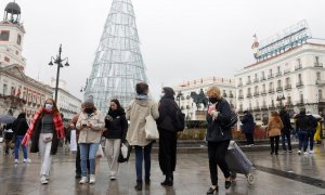 Varias personas caminan con mascarillas por la Puerta del Sol este viernes 24 de diciembre de 2021, día de Nochebuena.