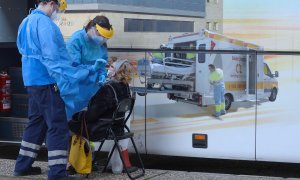 Unos enfermeros realizan un test a una mujer en el exterior de una de las doce unidades móviles que la Junta de Castilla y León ha contratado para hacer test de antígenos a la población que tenga síntomas durante todo el mes de enero, este martes en Vall