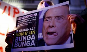 Un hombre sostiene un cartel que dice "Quirinal [sede de la Presidencia de la República] no es un Bunga Bunga",en una manifestación por la candidatura del ex primer ministro Silvio Berlusconi a la presidencia italiana, en Roma. REUTERS/Guglielmo Mangiapan