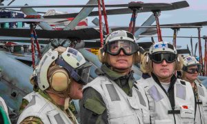 El secretario general de la OTAN, Jens Stoltenberg (C), observa un F-18 Super Hornet aterrizando en el portaaviones USS Harry S. Truman.