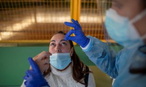 Un trabajador sanitario realiza un test de antígenos a una mujer durante el cribado poblacional celebrado en Ribadavia, en Ourense, este 27 de enero de 2022.