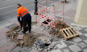 Un trabajador abre una zanja en la acera de una calle de Ronda (Málaga). REUTERS/Jon Nazca