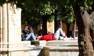 Unas turistas toman el sol junto a la fuente del Patio de los Naranjos de la Mezquita Catedral en Córdoba en una jornada de temperaturas primaverales