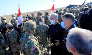 El secretario general de la OTAN, Jens Stoltenberg (C), y el presidente de Rumania, Klaus Iohannis (D), hablan con un oficial al mando de EE. UU. en la base aérea militar de Mihail Kogalniceanu, Rumania, el 11 de febrero de 2022.