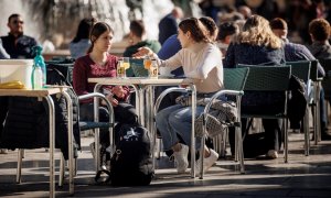 Varias personas disfrutan de un soleado día de invierno en una terraza en la ciudad de València.