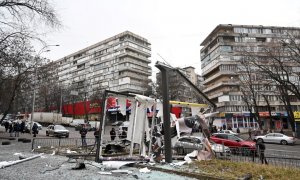 Se ve a personas fuera del área acordonada alrededor de los restos de un proyectil en una calle de Kiev el 24 de febrero de 2022.