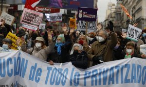 Varias personas portan una pancarta durante la manifestación que CCOO, UGT y medio centenar de colectivos sociales han convocado este sábado en Madrid, contra la Ley Ómnibus.