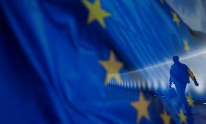 El reflejo de un hombre por un pasillo del Bundestag, en Berlin, sobre una bandera de la UE. REUTERS/Michele Tantussi