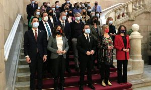 Membres del Govern, encapçalats pel president, Pere Aragonès, i diputats a l'escala noble del Parlament en una fotografia conjunta per mostrar suport a la jornada de mobilitzacions de la comunitat educativa en defensa del català a l'escola.