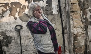 Una mujer observa el estado de su vivienda tras sufrir los efectos de un bombardeo en el barrio de Shevchenko, en Kiev, este miércoles. Aris Messinis/AFP