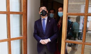 El presidente de la Junta, Juanma Moreno, mira al cielo antes de entrar en el pleno durante la sesión plenaria ordinaria en el Parlamento de Andalucía, a 24 de marzo de 2022.