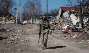 Un soldado ucraniano pasea por un barrio destruido en el este de la región de Kiev.