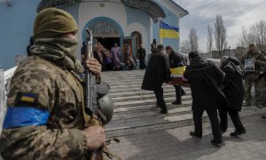 Compañeros de un soldado fallecido le rinden homenaje este domingo 27 de marzo de 2022 en el cementerio de Yuzhne (Ucrania).