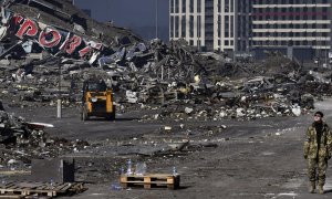 28/03/2022 Un soldado ucraniano camina junto a un centro comercial dañado en el distrito de Podilskyi tras un ataque con misiles rusos, que tuvo lugar el 23 de marzo de 2022.