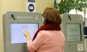 Una mujer recoge su turno en una oficina de la Agencia Tributaria. E.P./Marta Fernández