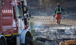 Un bombero trabaja en los restos de un incendio en un asentamiento chabolista de Lepe, en una imagen de archivo.