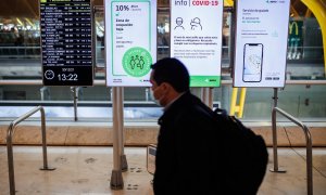 28/04/2022. Una persona pasa delante de unos paneles con las medidas de seguridad covid en la Terminal 4 del Aeropuerto Adolfo Suárez-Madrid Barajas, a 30 de diciembre de 2021.