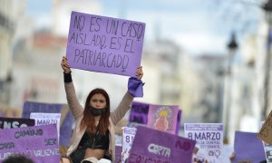 Una joven con un cartel en una manifestación estudiantil feminista por el 8M, Día Internacional de la Mujer, en la Puerta del Sol, a 8 de marzo de 2022, en Madrid