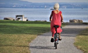 Una mujer pasea en bici camino de la playa.