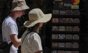 19/05/2022-Dos turistas pasean con sombreros para protegerse del calor que impera en València este jueves 19 de mayo