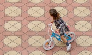 Una niña jugando con su bicicleta en la Plaza de España del Parque de Maria Luisa, en Sevilla.