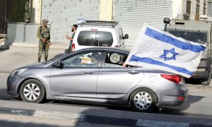 26/05/2022 Un coche circula con una bandera de Israel durante las protestas palestinas en Huwara