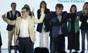 El secretario general de JxCat, Jordi Sànchez (i), toma de la mano al presidente de la formación, Carles Puigdemont (d), durante el segundo congreso de JxCat