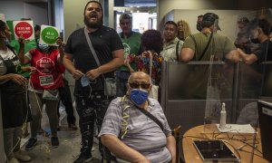 Activistas por el derecho a la vivienda protestan en una sucursal de CaixaBank en Vallecas (Madrid) para evitar una "oleada de desahucios".