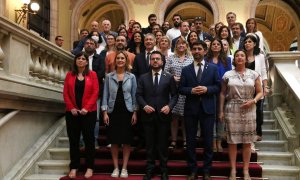 El president del Govern, Pere Aragonès, amb més representants de l'executiu, i dels grups parlamentaris de PSC-Units, ERC, Junts i En Comú Podem, a les escales del Parlament després d'aprovar la llei del català per respondre la sentència del 25%.