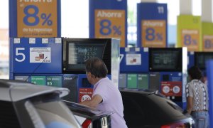 09/06/2022 Dos personas repostan en una gasolinera de Madrid